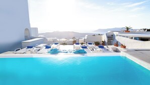 A rooftop pool area with lounge chairs and potted plants, overlooking a mountainous landscape. - Pantelia Suites (Santorini)