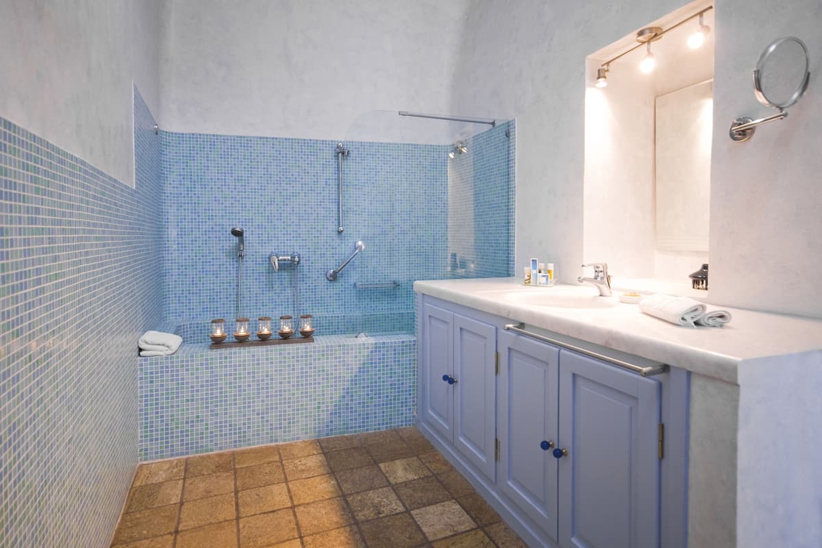 junior suite (caldera view) | bathroom | shower, designer toiletries, hair dryer, bathrobes