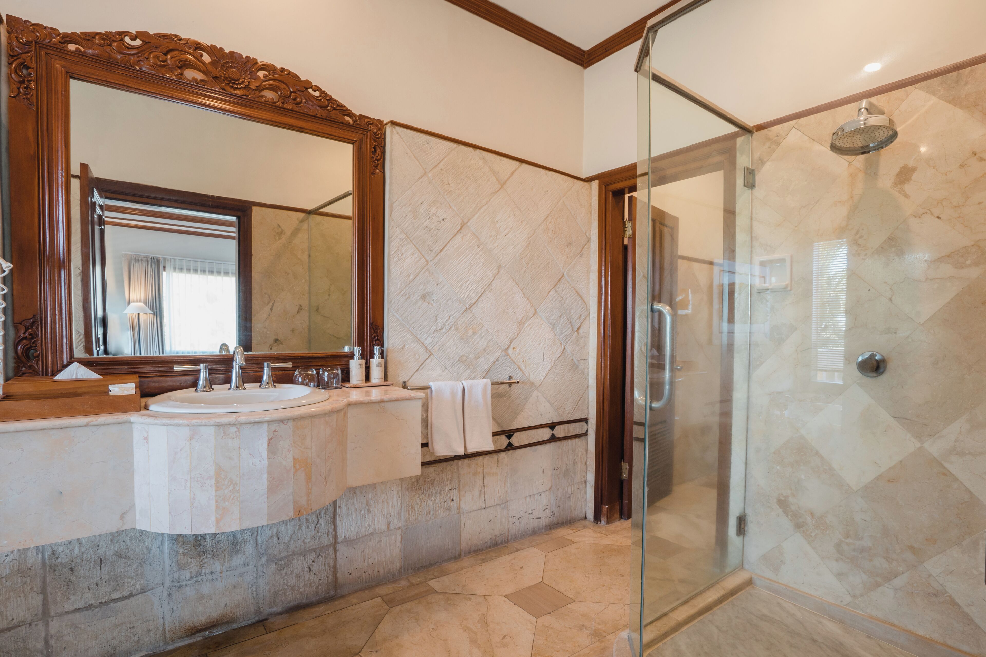 A bathroom with two sinks, a large mirror, and a glass-enclosed shower.