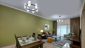 Een moderne woonkamer met een eethoek, een zithoek, een salontafel en een tv-meubel.