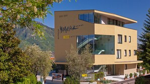 A modern hotel with a flat roof, large windows, and a sign that says "take off". - Hotel Marlena (Marlengo)