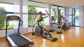 Un gimnasio con cinta de correr, elíptica y bicicleta estática.