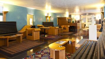 Relax in the hotel lobby, featuring comfortable seating areas, polished floors, and vibrant rugs.
