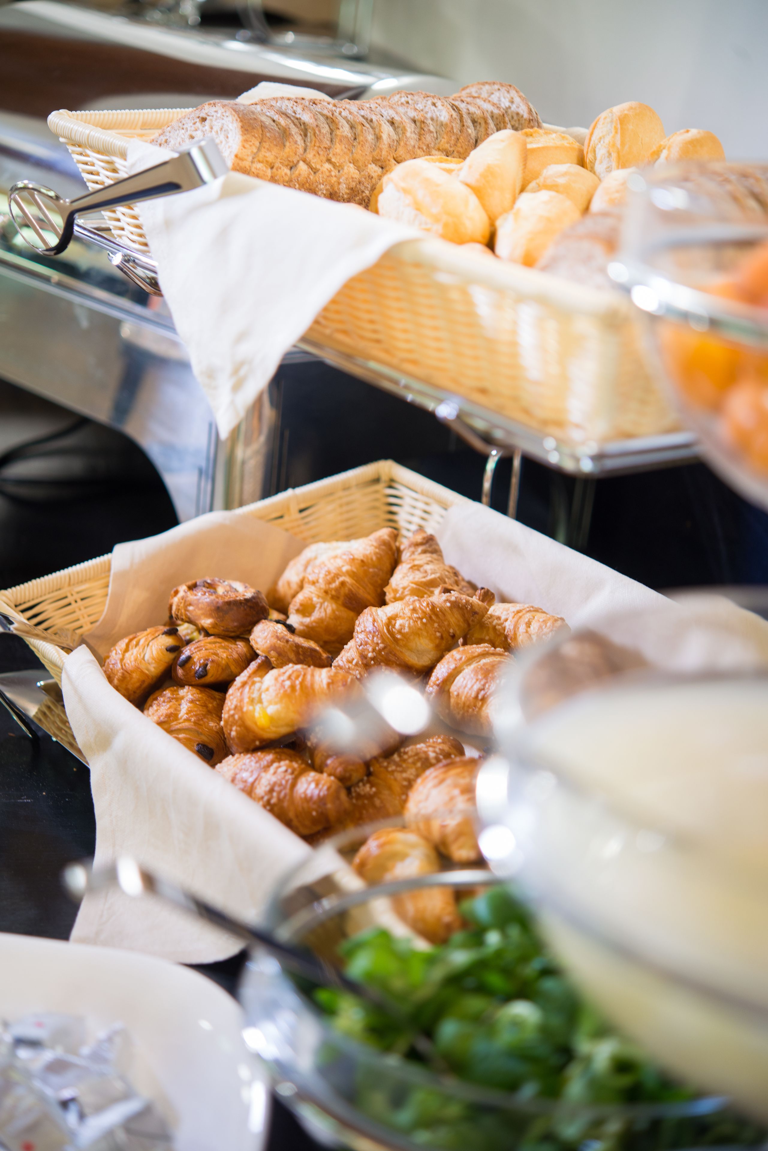 Un bufé con diversas opciones de panadería, incluyendo pan y pastelería.