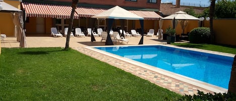 Alberca al aire libre por temporada y sombrillas en la alberca