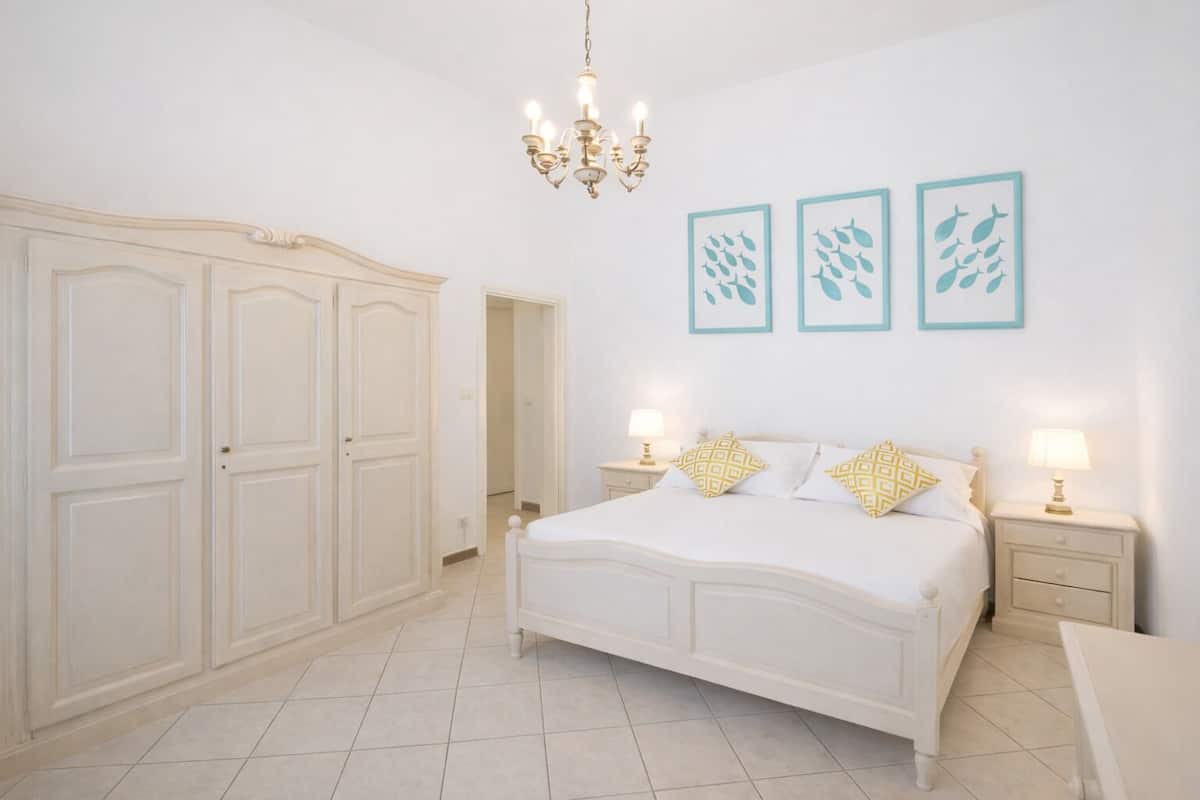 Une chambre dotée d’une grande armoire, d’un lit agrémenté d’oreillers à motifs et de décorations murales.