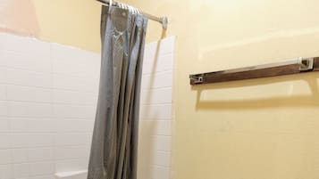 A bathroom with a bathtub, toilet, and a shower curtain.