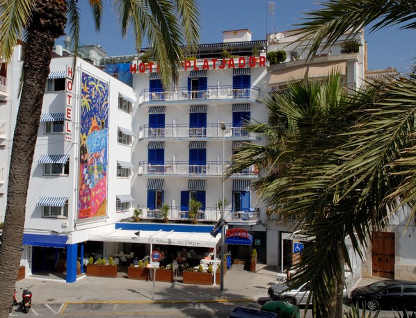 Un hotel de varios pisos con balcones, un restaurante y un letrero que dice "HOTEL".