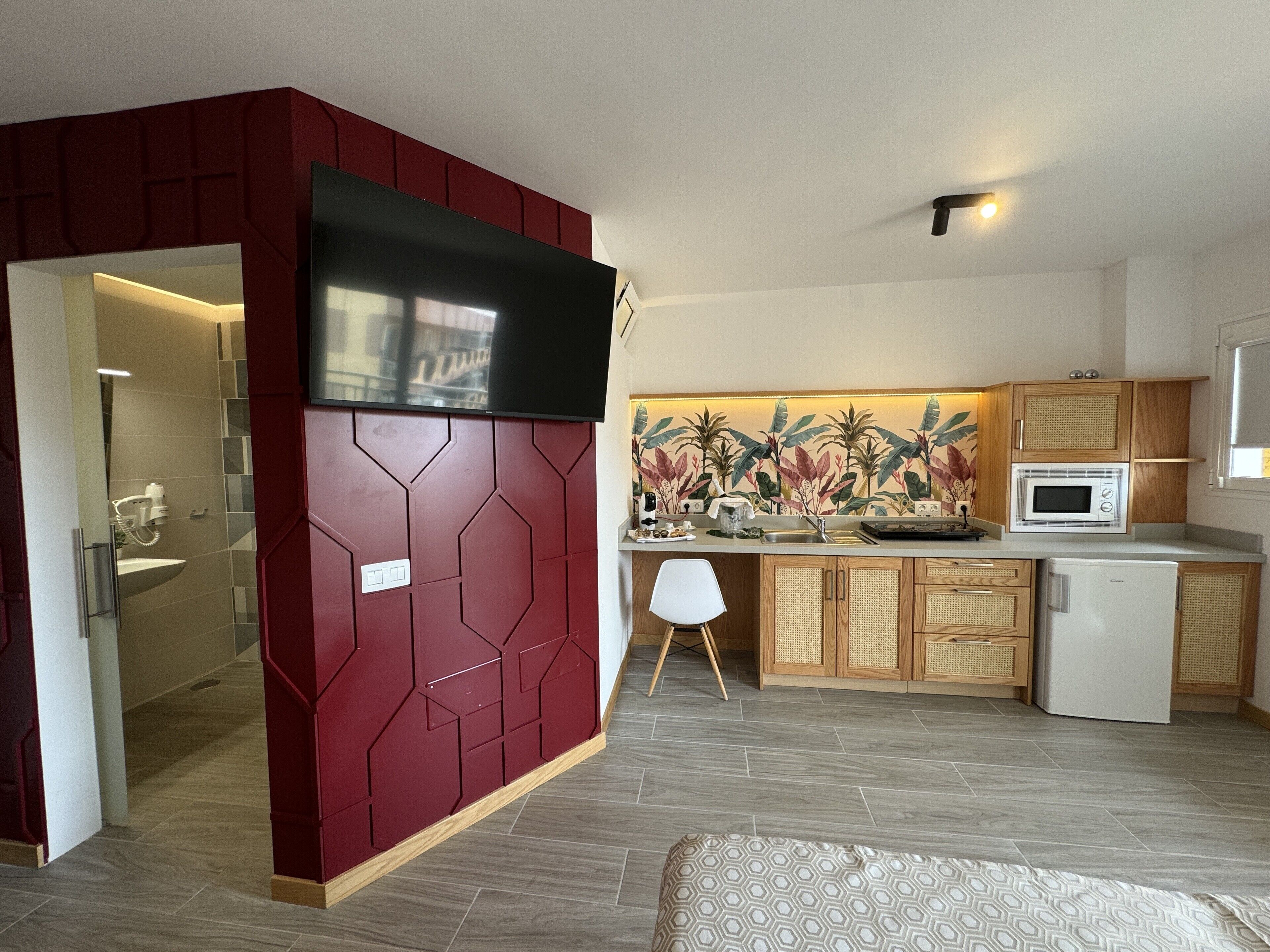 A compact living space with a kitchenette, a small dining area, and a bathroom.