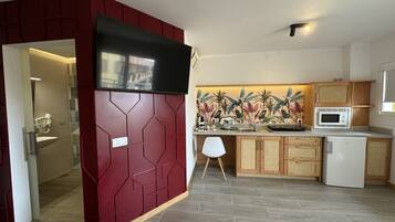 A compact living space with a kitchenette, a small dining area, and a bathroom.