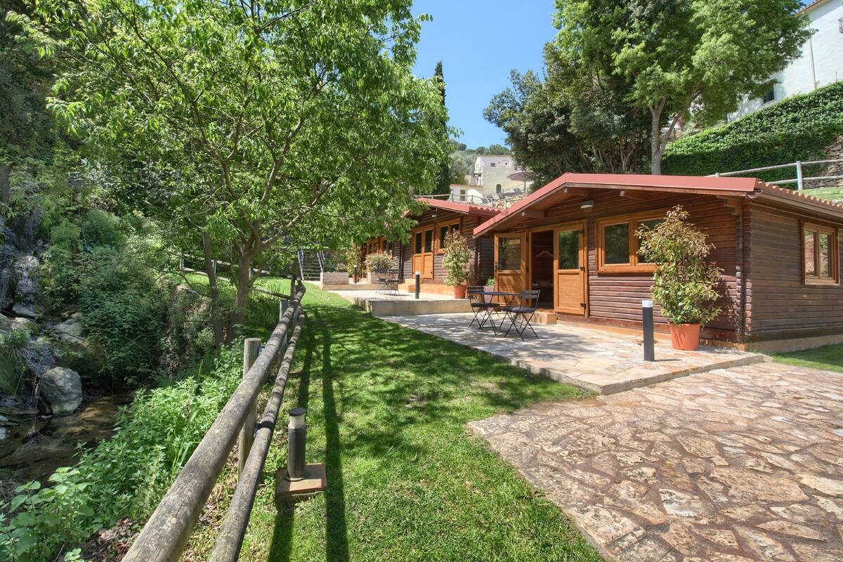A wooden cabin with a stone pathway leading to a patio area.