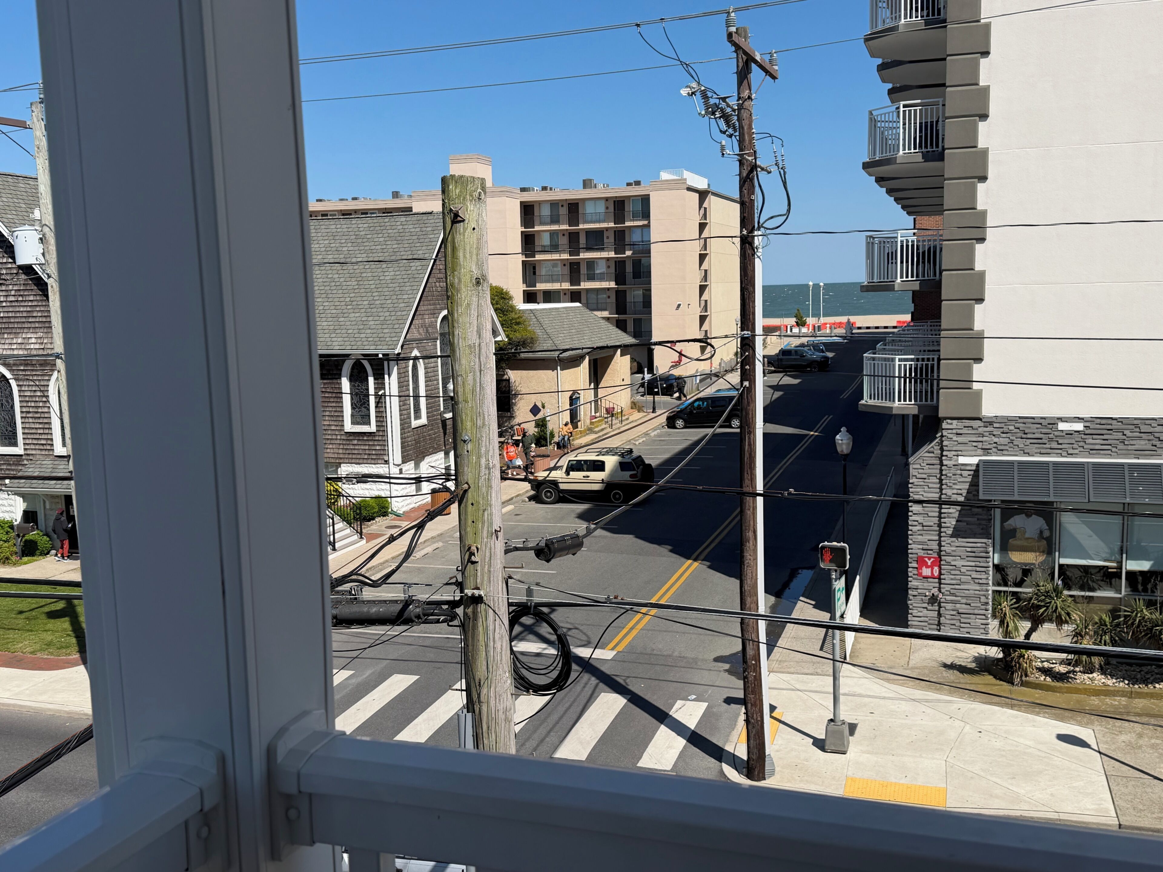 A street view with buildings, a crosswalk, and a pedestrian.