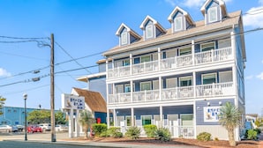 A two-story building with a balcony on the second floor, a sign for 'Beach Bum Inn', and a palm tree in front. - Beach Bum Inn (Ocean City)