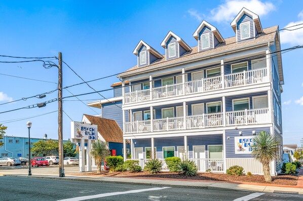 A two-story building with a balcony on the second floor, a sign for 'Beach Bum Inn', and a palm tree in front. - Beach Bum Inn (Ocean City)