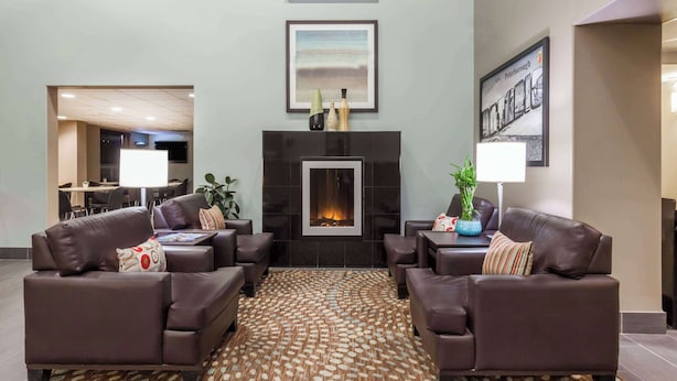 Una sala de estar moderna con chimenea, dos sofás, una mesa de centro y una alfombra estampada.