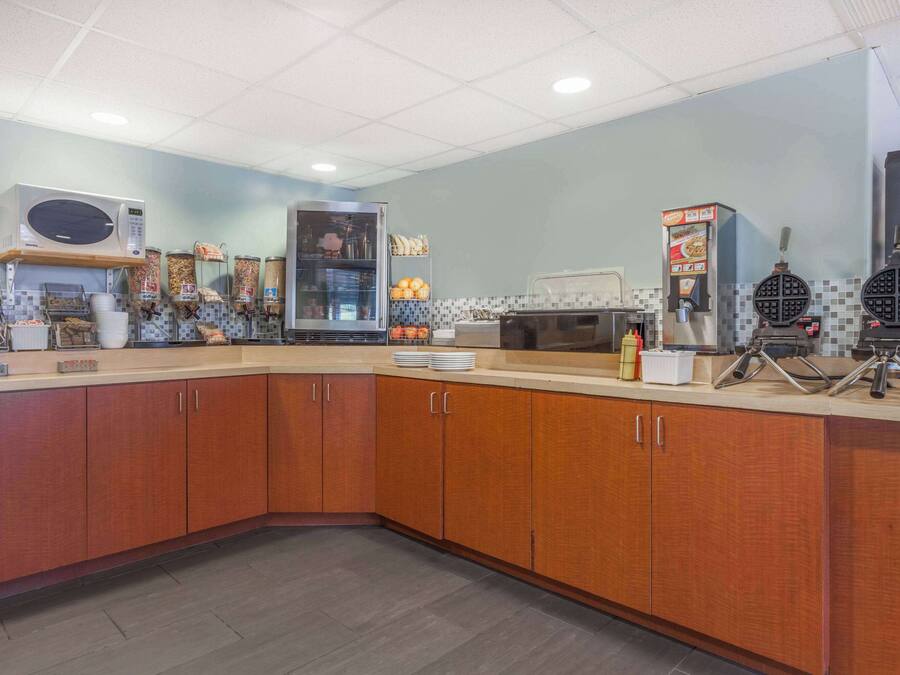 A modern kitchen with a microwave, toaster, and waffle maker.
