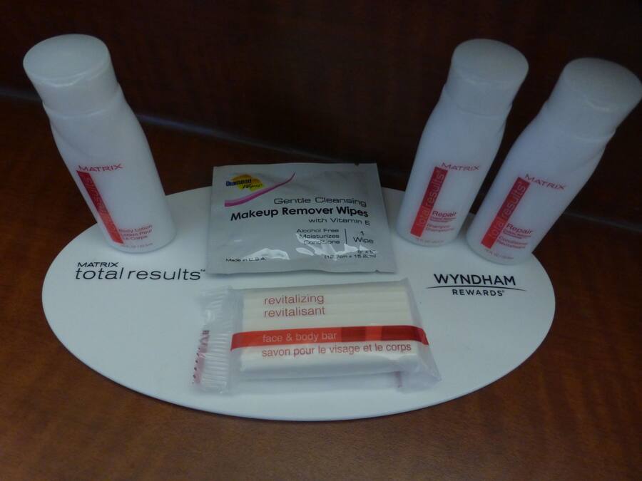 A display of skincare products including makeup remover wipes, body lotion, and a bar soap.