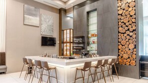 Una cocina moderna con una isla central, taburetes de bar y un espacio para vinos empotrado.
