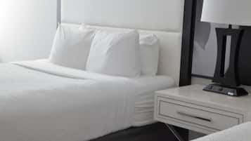 Une chambre d’hôtel avec un lit bien fait, une table de chevet avec une lampe et un tiroir.