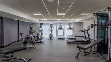 A gym with treadmills, elliptical machines, and weightlifting equipment.