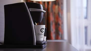 A coffee machine with a cup labeled "Coforte Hotel Quebec" on a table.
