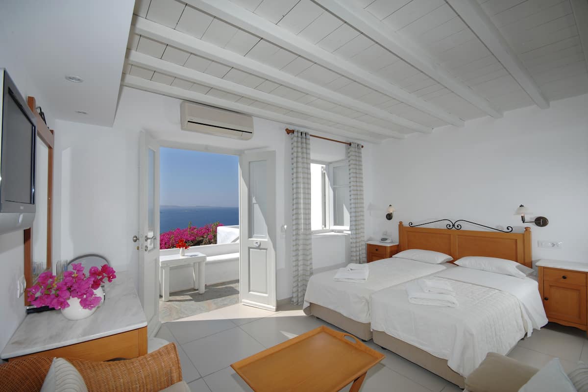 Un dormitorio con cama, mesita de noche y vistas al mar.