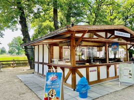 Un puesto de helados de madera con un letrero que dice 'Selbstbedienung' (servicio propio).