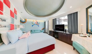 A modern hotel room with a large bed, a TV, and a desk area.
