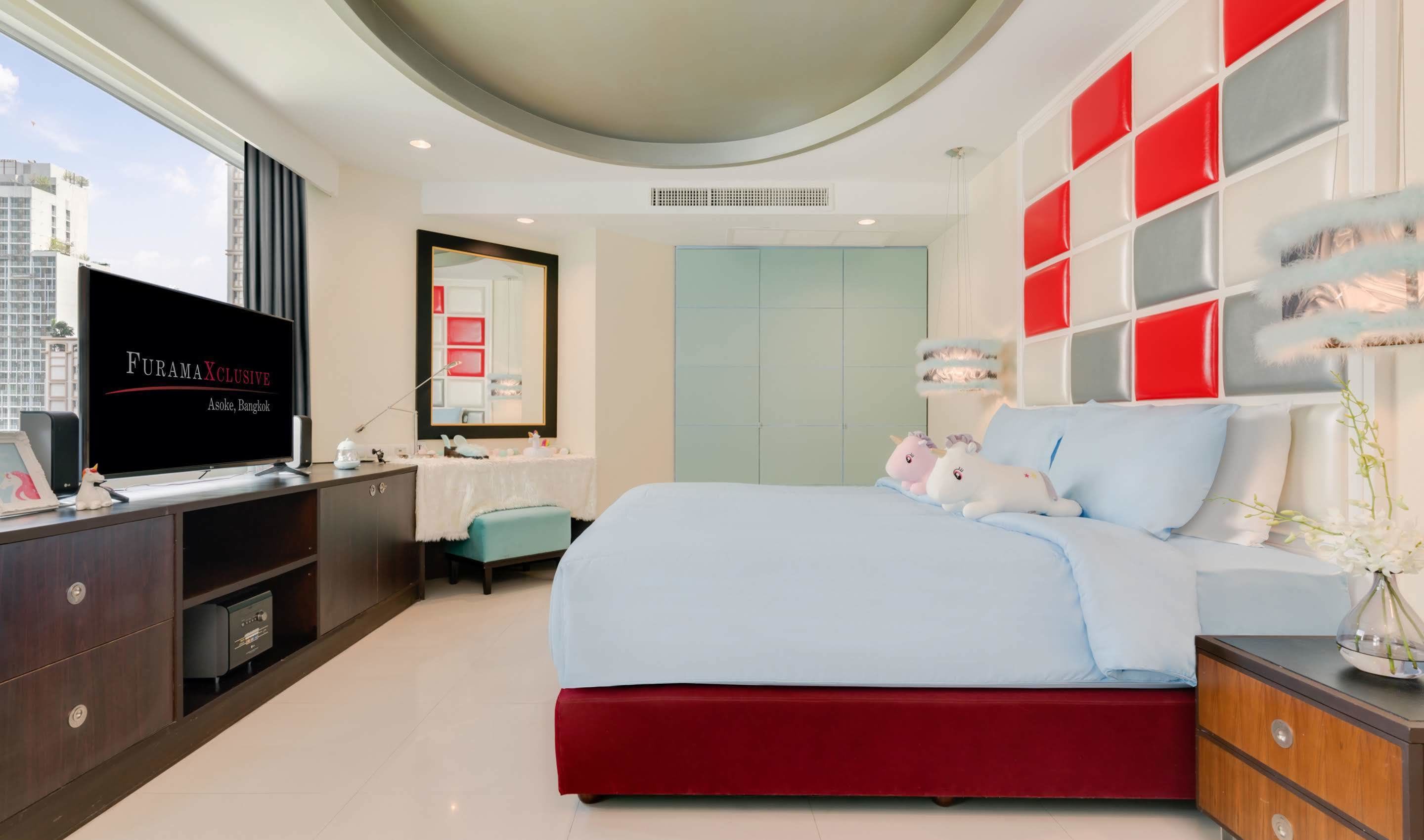 Une chambre à coucher moderne, équipée d’une télévision, d’un lit, d’une commode et d’une armoire.