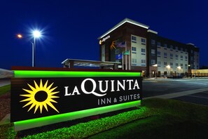 A La Quinta Inn & Suites sign with a sun emblem, indicating the hotel name and type.