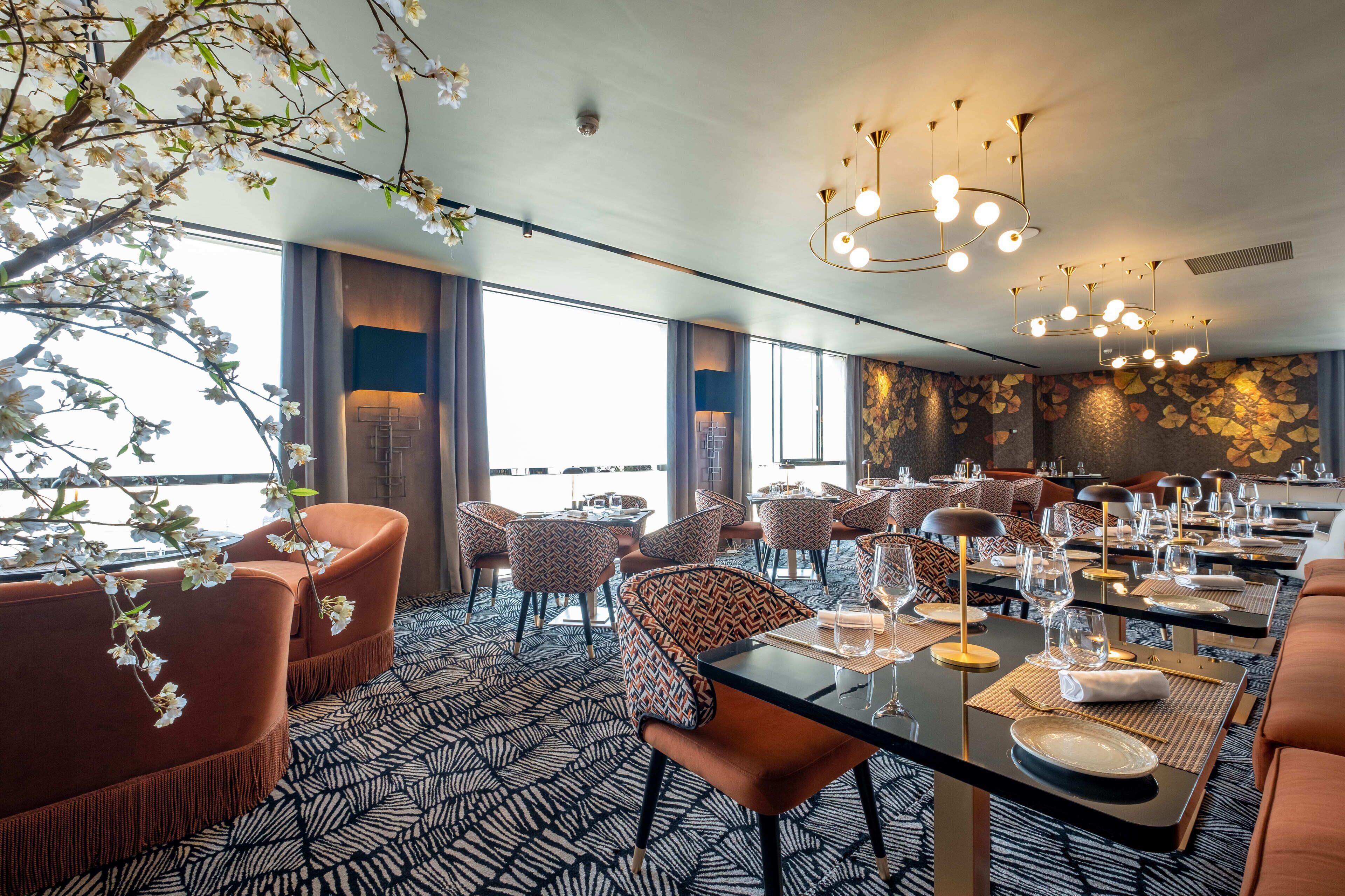 Un espace de restauration moderne avec des tables rondes, des chaises et un lustre.