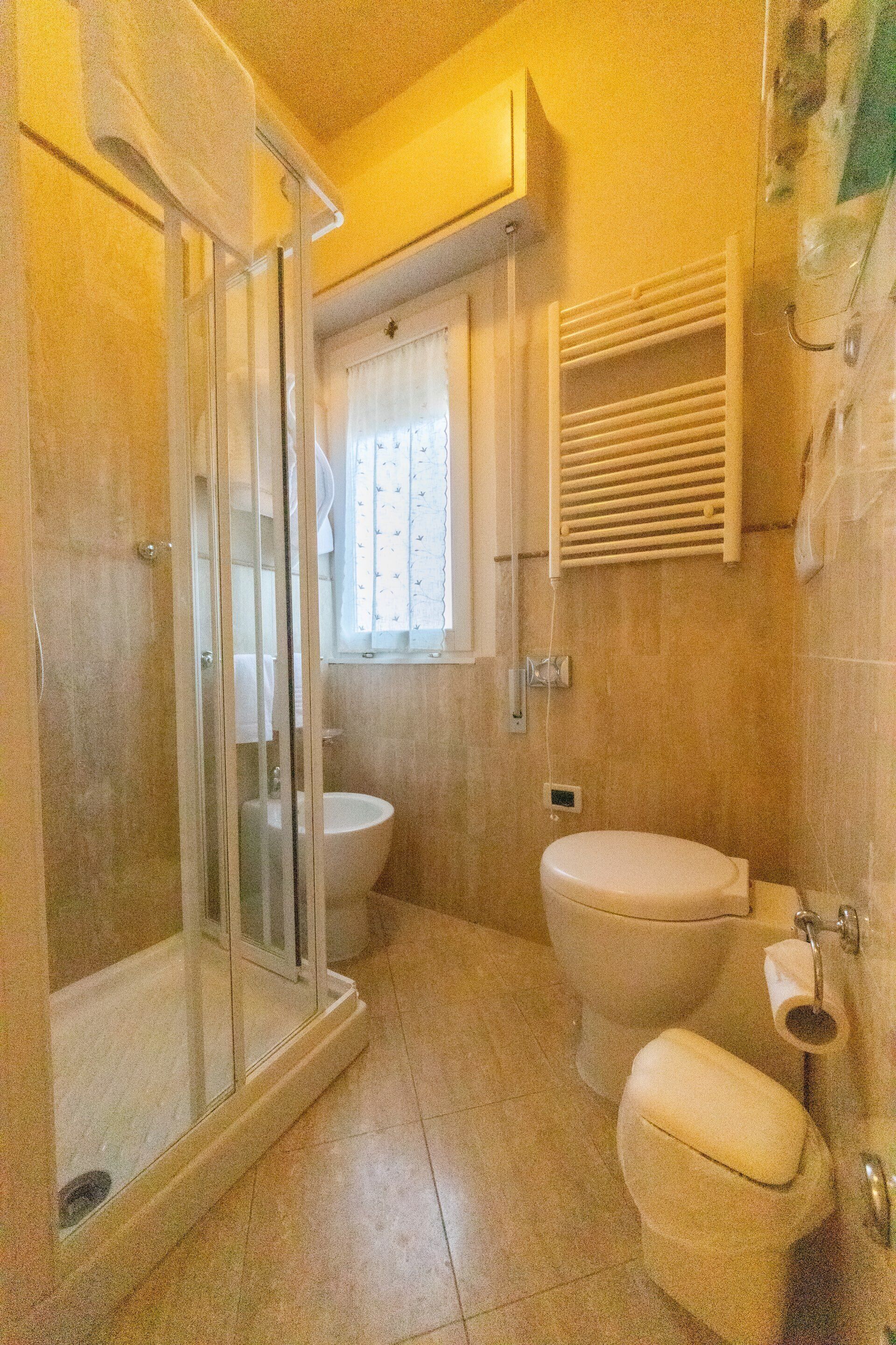 Une salle de bain avec une douche à parois de verre, des toilettes et un lavabo.