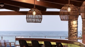 A bar area with wicker chairs and a view of the ocean. - Ikaros Beach Resort & Spa - Adults Only (Hersonissos)