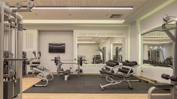 A modern gym with various exercise equipment, a large mirror, and a television.