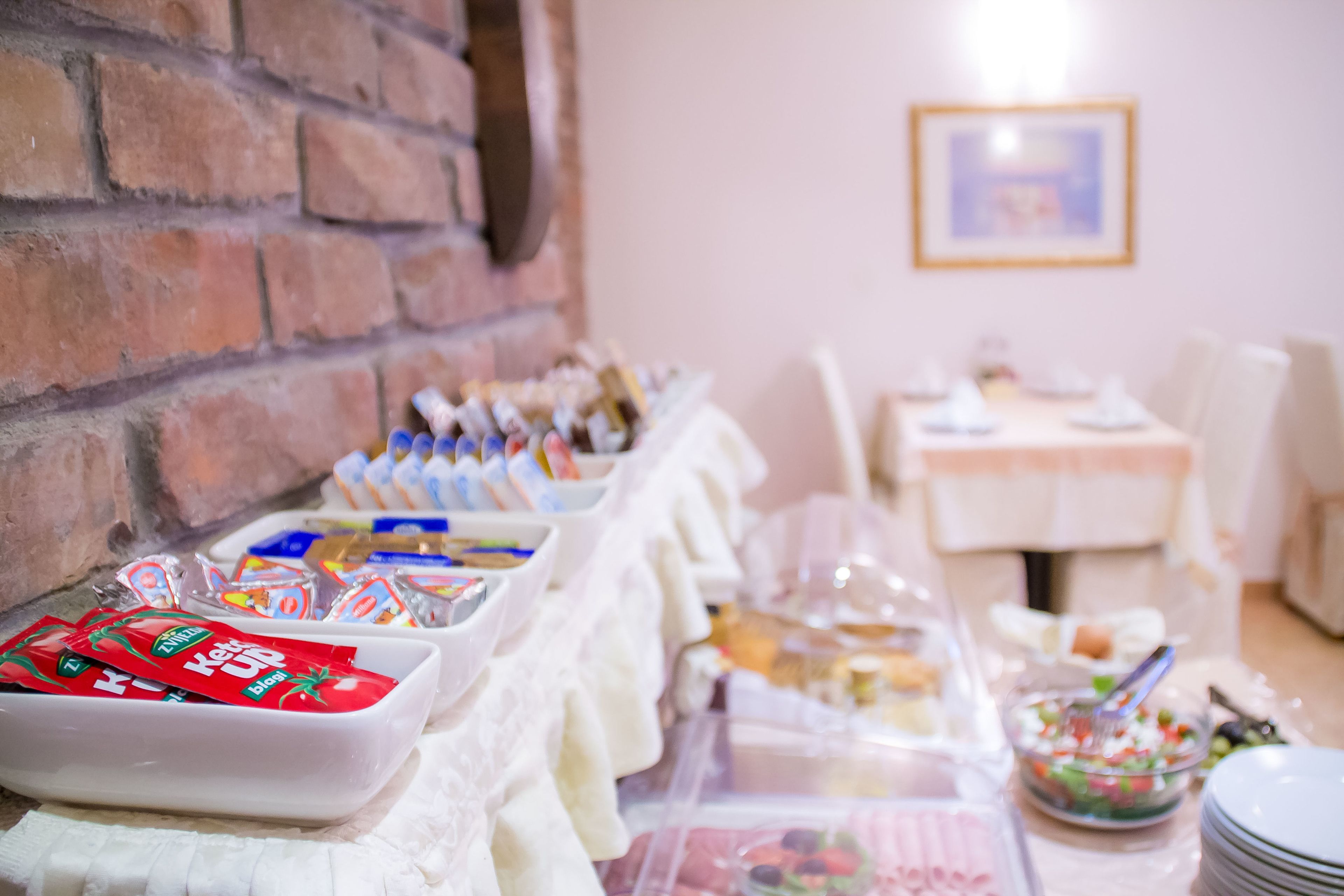 A buffet setup with various food items and condiments.