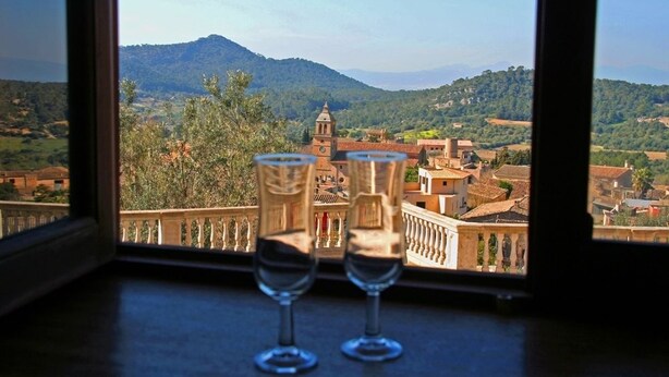 Two wine glasses on a balcony with a view of a town and mountains. - Recó de Randa (Algaida)