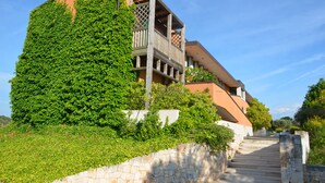 Un bâtiment doté d’un escalier en pierre menant à un balcon en bois.