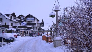 A snow-covered street with a hotel named "Hotel Silveaster" and a sign indicating a ski resort. - Hotel Silvester (Cerklje na Gorenjskem)