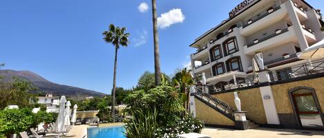 Experience the tranquil atmosphere of AZZO, surrounded by lush gardens and a serene pool area.
