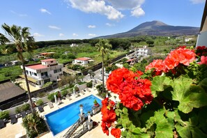 Un área residencial con piscina, palmeras y una montaña al fondo.