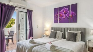 A hotel room with two beds, a balcony, and purple curtains. - Quinta do Paraíso (Lagoa)