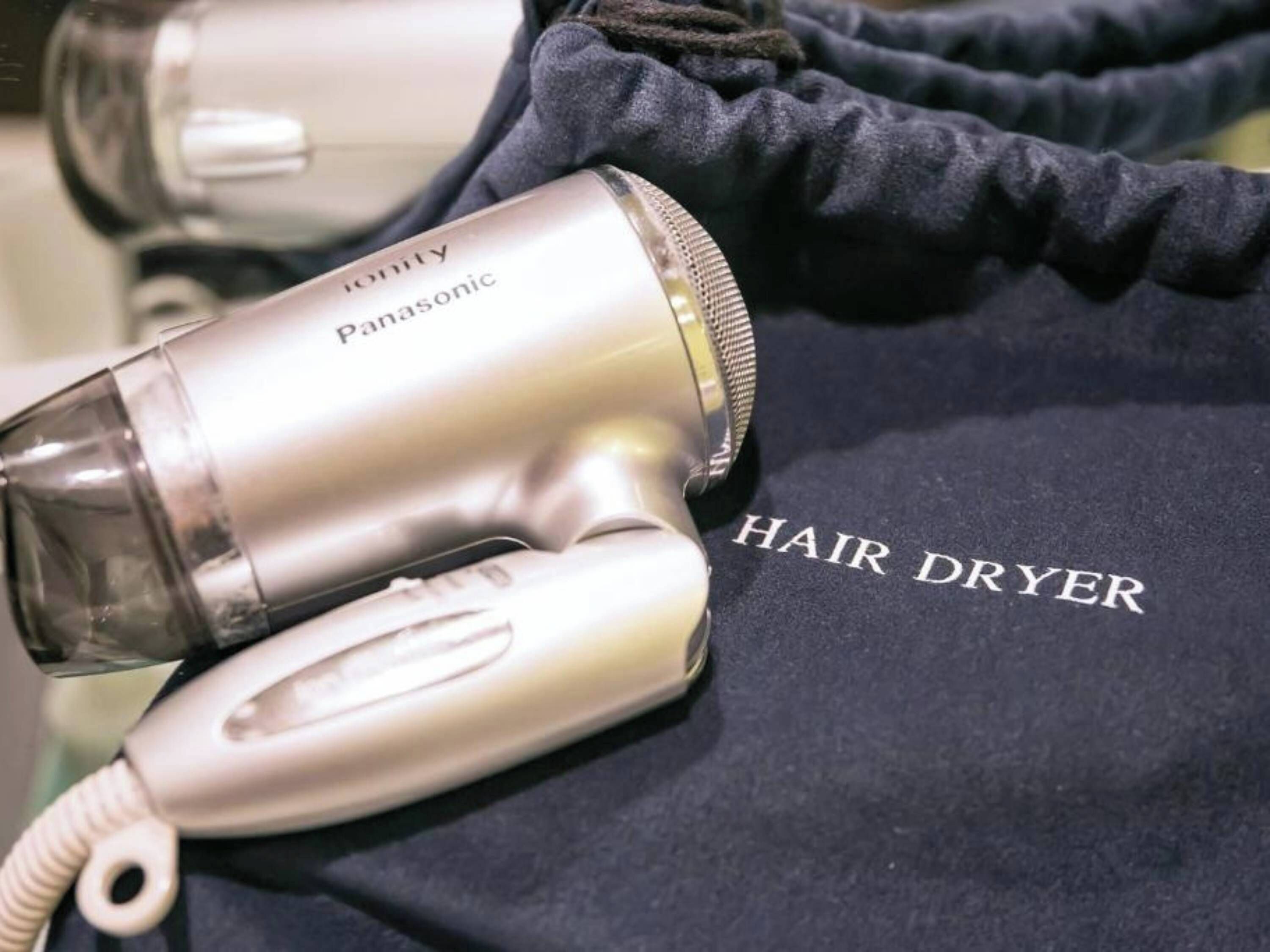 A hair dryer and a dark blue cloth with "HAIR DRYER" written on it.