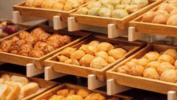 Une vitrine de boulangerie présentant divers produits de boulangerie disposés sur des plateaux en bois.