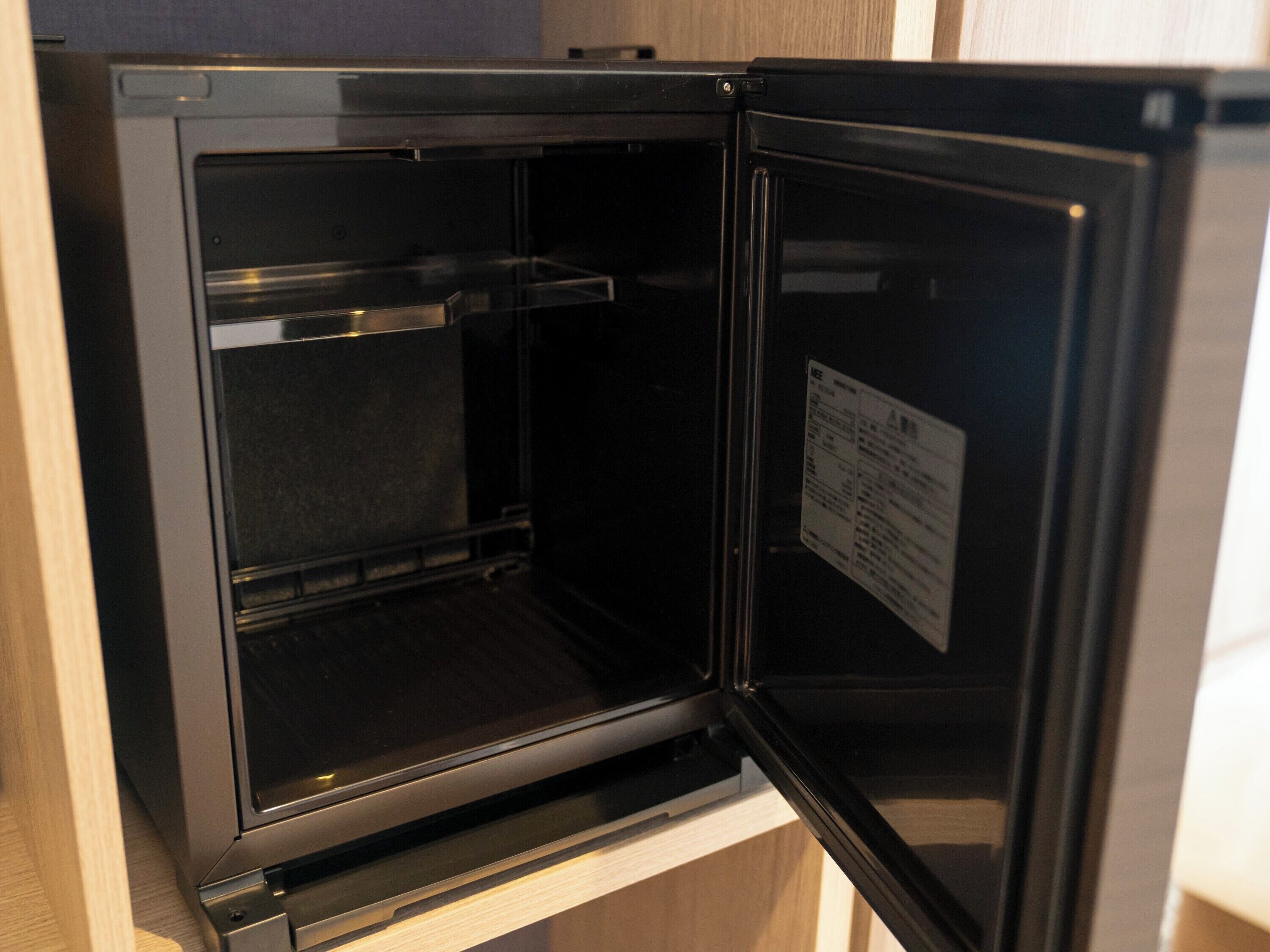Un refrigerador abierto con un panel de control a la derecha.