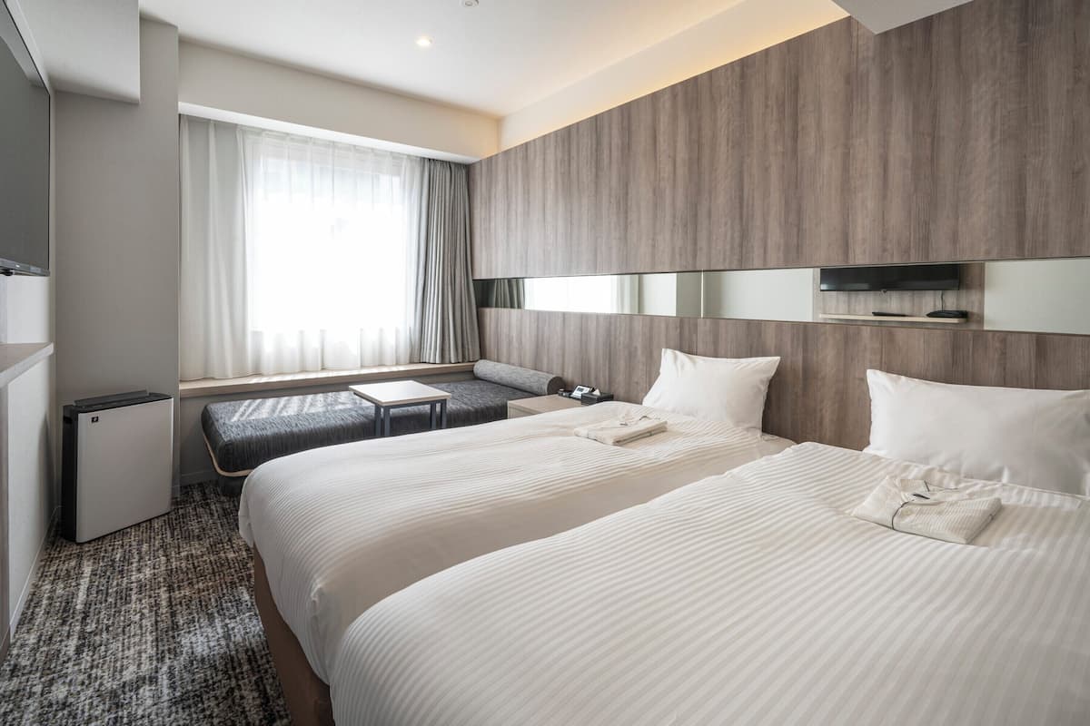 Een moderne hotelkamer met een groot bed, een bureau en een aan de muur bevestigde televisie.