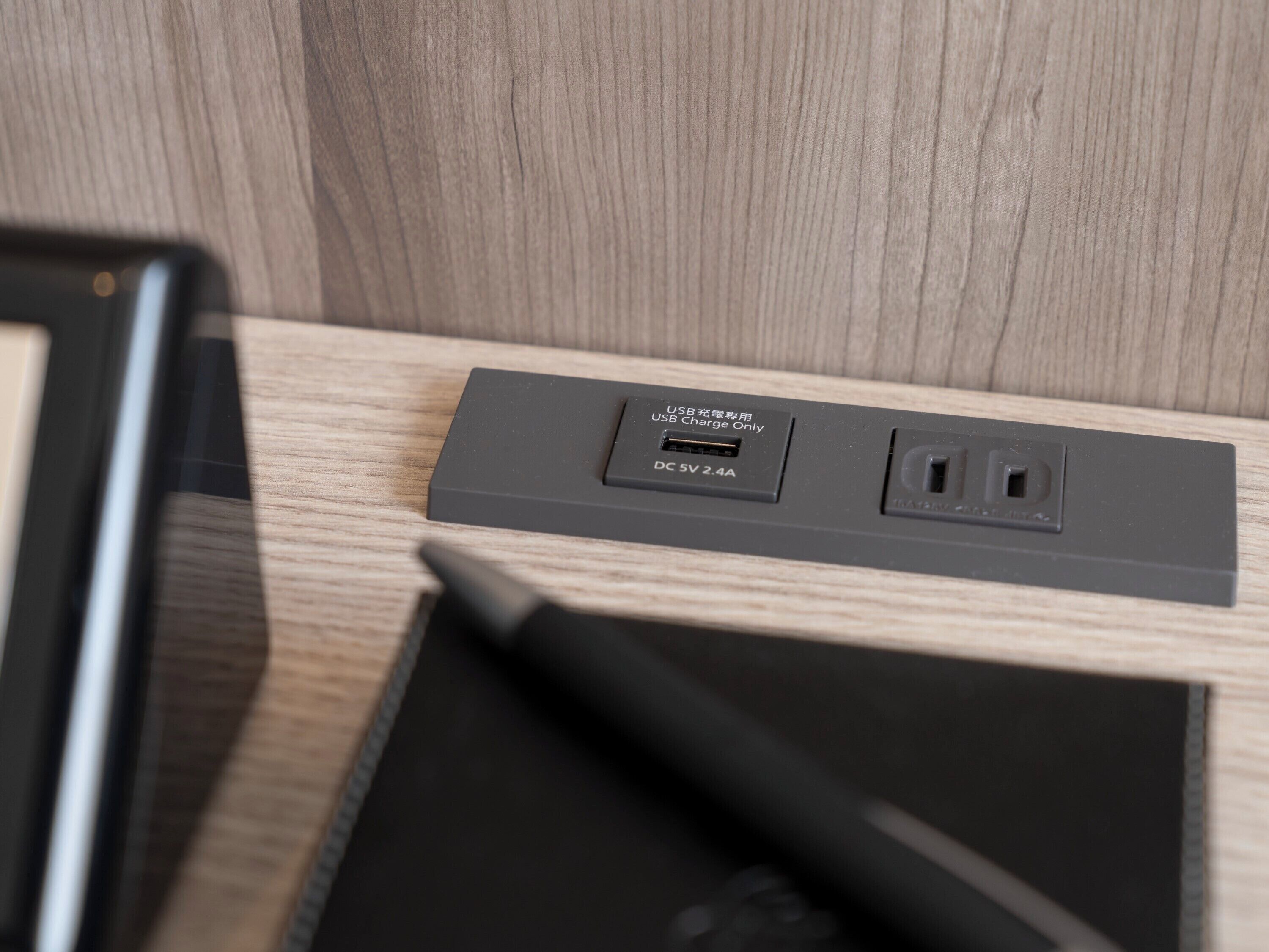 Eine USB-Ladestation mit einem 5V 2,4A DC-Ausgang, einem USB-Anschluss und einem 3,5-mm-Audioanschluss.