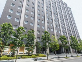 A multi-story hotel with a modern design, featuring a uniform facade and evenly spaced windows.