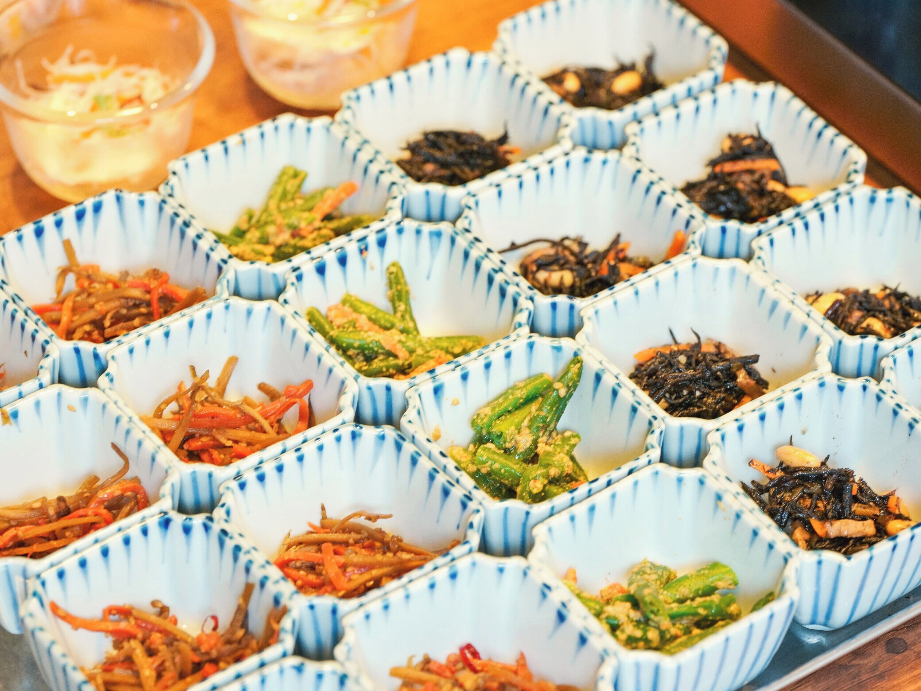 A tray of food with various dishes in blue and white patterned containers.