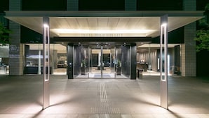 De ingang van Hotel Brighton City met een modern ontwerp, met een glazen gevel en een helder zicht in de lobby.