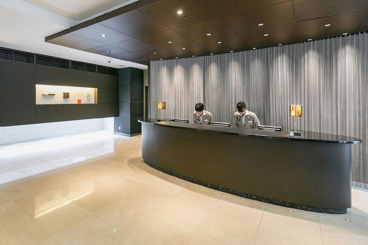 Ein Empfangsschalter mit modernem Design, ein Check-in-Schalter und eine Wandtafel mit Informationen.